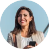 Smiling woman holding smartphone, representing satisfied client experience with Cactus Home Offer's home-selling services.